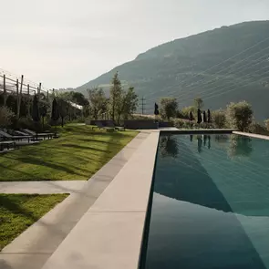 Infinity Pool mit Liegewiese und Blick auf die Berge
