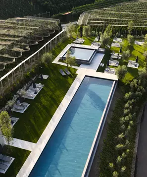 Luftaufnahme von Sportpool und Relaxpool mit Liegen zwischen Hangterrassen